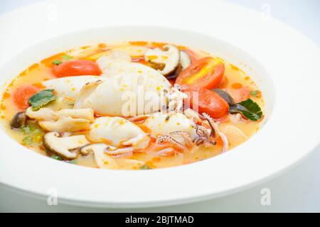 Kalmare und Zitronengras würzige Suppe mit Pilzen, Tomaten und Kräutern Stockfoto