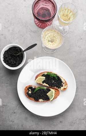 Brotscheiben mit schwarzem Kaviar und Butter auf dem Teller Stockfoto