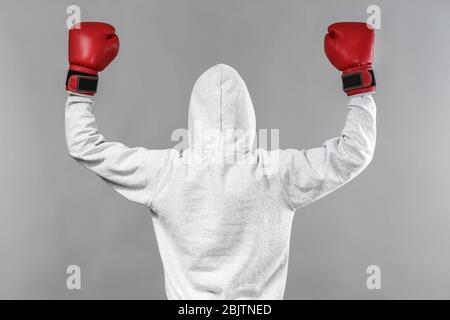 Boxer in Kapuzenpullover posiert auf grauem Hintergrund Stockfoto