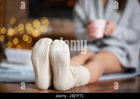Frau in warmen Socken, die sich am Wintertag zu Hause entspannt Stockfoto