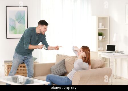 Wütend Mann schimpft seine Frau für zu viel Ausgaben zu Hause Stockfoto