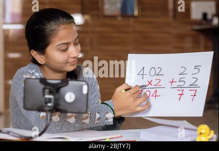 Mädchen, die online virtuellen Kurs auf dem Handy, beschäftigt in Unterricht zu Hause während covid-19 oder Coronavirus Pandemie Krise - Konzept der E-Unterricht Stockfoto