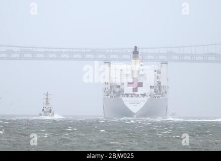 New York, Usa. April 2020. Das Schiff der USNS Comfort Navy fährt am Pier 90 ab und unterquert am Donnerstag, dem 30. April 2020, die Verrazzano-Narrows Bridge in New York City. Das schwimmende Krankenhaus in Form eines Marineschiffes kam Ende März in New York City an, um den Druck auf die Krankenhäuser zu verringern, die bereits mit Coronavirus-Pandemiepatienten überfordert waren. Foto von John Angelillo/UPI Quelle: UPI/Alamy Live News Stockfoto