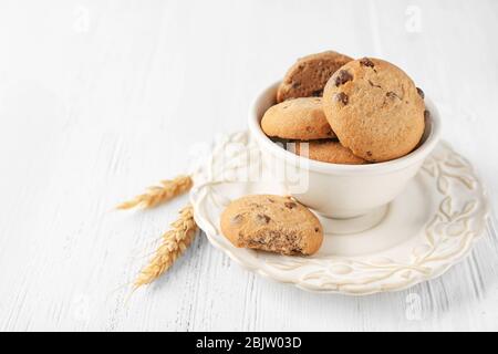 Leckere Haferflocken-Kekse mit Schokolade Chips in Schüssel auf dem Tisch Stockfoto