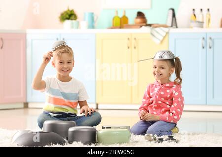 Süße kleine Kinder spielen mit Küchenutensilien zu Hause Stockfoto