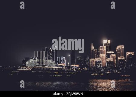 Chongqing, China - August 2019 : Nachtsicht auf die Stadt Chongqing beleuchtet Jialing und Yangtze mit beleuchteten Wolkenkratzern im Hintergrund Stockfoto