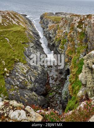 Tiefer schmaler Bach von Uaimh na bhFiach in Kalksteinfelsen der Insel Inishbofin vor der Küste von Connemara West von Irland Stockfoto