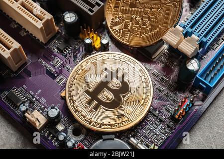 Goldene Bitcoins auf PC-Motherboard Stockfoto