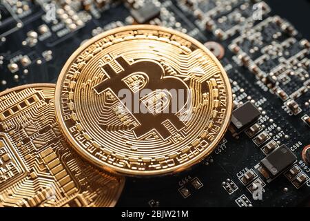 Goldene Bitcoins auf der Platine, Nahaufnahme Stockfoto