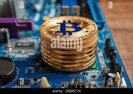Goldene Bitcoins auf PC-Mainboard, Nahaufnahme Stockfoto