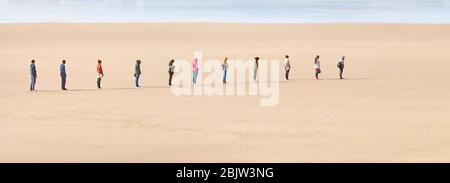 Junge Leute stellen sich zwei Meter auseinander, um während der Coronavirus-Pandemie 2020 - Großbritannien - an einem Strand soziale Distanz zu bewahren Stockfoto