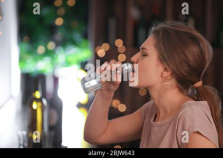 Junge Frau, die in der Bar trinkt. Alkoholismus Problem Stockfoto