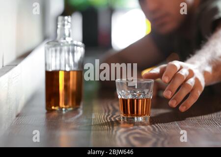 Mann, der nach einem Glas Getränk in der Bar greift. Alkoholismus Problem Stockfoto