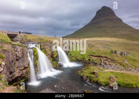 Lange Sicht auf den Kirkjufellsfoss Wasserfall mit Kirkjufell ('Kirchberg') auf der Halbinsel Snæfellsnes, Island. Stockfoto