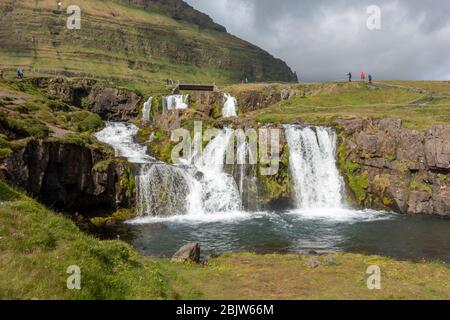 Der Kirkjufellsfoss Wasserfall liegt gegenüber Kirkjufell ("Kirchberg") auf der Halbinsel Snæfellsnes, Island. Stockfoto