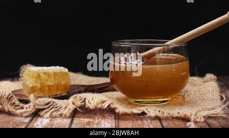 Honig ist gesund, mit einem Honiglöffel umrühren Stockfoto