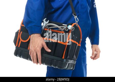 Junger Klempner in Uniform mit Werkzeugtasche auf weißem Hintergrund Stockfoto