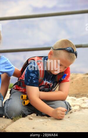 Junge auf Reisen Schreiben in Kreide auf Stein Stockfoto