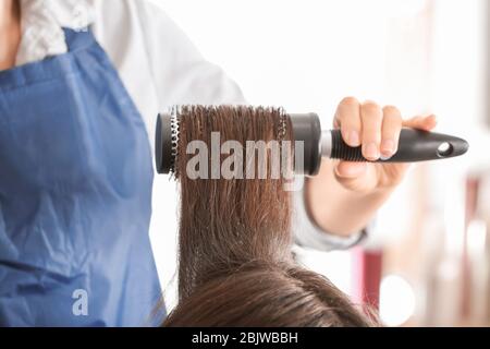 Professioneller Friseur Bürsten Client Haar im Schönheitssalon Stockfoto