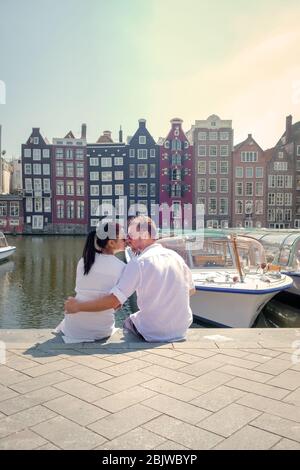 Ein Paar auf einer Städtereise nach Amsterdam, Männer und Frauen entspannen sich im Frühjahr 2020 April an den Grachten von Amsterdam in Europa Niederlande Stockfoto