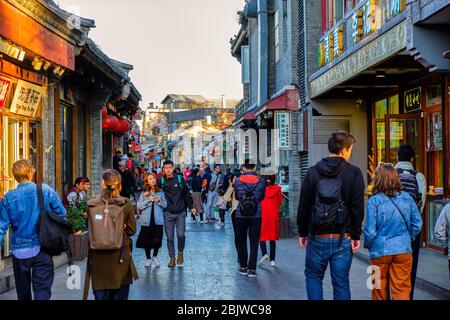 Peking / China - 9. Oktober 2018: Alte Gulou Hutong Straße, mit vielen traditionellen Geschäften und Restaurants in Peking, China Stockfoto