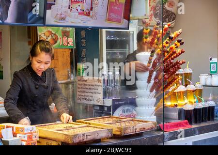 Peking / China - 9. Oktober 2018: Verkäufer verkaufen Essen und Getränke in der beliebten Fußgängerzone entlang des Lotusmarktes am Qianhai See in der Innenstadt bei Stockfoto