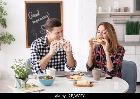 Glückliches Paar, das zusammen in der Küche frühstücken kann Stockfoto