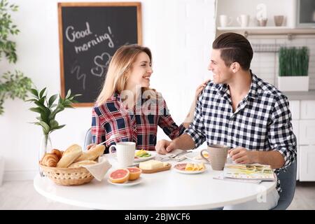 Glückliches Paar, das zusammen in der Küche frühstücken kann Stockfoto