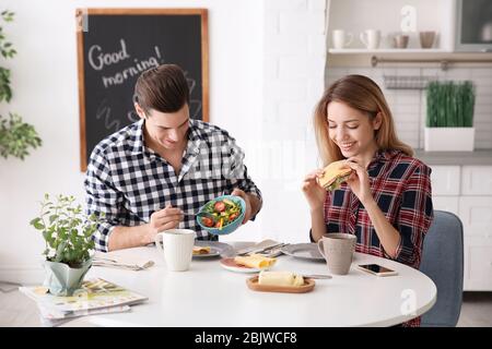 Glückliches Paar, das zusammen in der Küche frühstücken kann Stockfoto