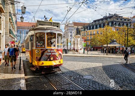 An einem sonnigen Sommertag fährt ein Trolley durch die Straßen von Lissabon, Portugal, nahe dem Praça Luis de Camões Platz. Stockfoto