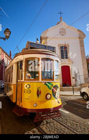 Die Trolleys fahren entlang der Largo Santa Luzia, während sie an der katholischen Kirche Igreja de Santa Luzia im Stadtteil Alfama in Lissabon, Portugal, vorbeifahren. Stockfoto