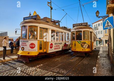 Die Trolleys fahren entlang der Largo Santa Luzia, während sie an der katholischen Kirche Igreja de Santa Luzia im Stadtteil Alfama in Lissabon, Portugal, vorbeifahren. Stockfoto