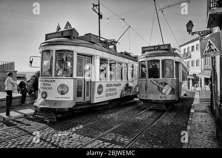 Die Trolleys fahren entlang der Largo Santa Luzia, während sie an der katholischen Kirche Igreja de Santa Luzia im Stadtteil Alfama in Lissabon, Portugal, vorbeifahren. Stockfoto