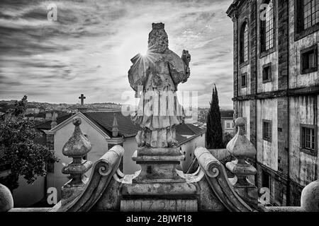 Die Sonne geht auf einer Statue auf dem Gelände der Universität von Coimbra in Zentralportugal unter Stockfoto