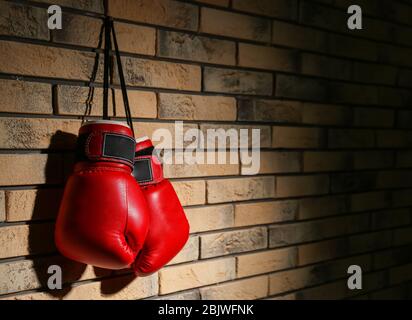 Boxhandschuhe auf Ziegelmauer Stockfoto