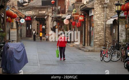 Peking, China. April 2020. Eine chinesische Frau geht mit einer schützenden Gesichtsmaske durch ein leeres Touristengebiet, obwohl die Regierung erklärt hat, dass die Bedrohung durch den Ausbruch von Covid-19 am Donnerstag, dem 30. April 2020, in Peking im Wesentlichen beendet ist. Chinas Hauptstadt senkte ihre Notfallreaktion auf die neuartige Coronavirus-Pandemie von der obersten Ebene auf die zweite Ebene heute, das "neueste Zeichen der Wiederherstellung der sozialen Ordnung, da die Epidemie-Bedingungen gelockert wurden", laut staatlichen Medien. Foto von Stephen Shaver/UPI Quelle: UPI/Alamy Live News Stockfoto