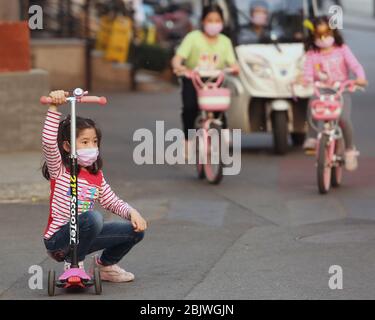 Peking, China. April 2020. Chinesische Mädchen tragen weiterhin Schutzmaske draußen, obwohl die Regierung erklärt hat, dass die Bedrohung durch den Ausbruch von Covid-19 am Donnerstag, dem 30. April 2020, in Peking im Wesentlichen beendet ist. Chinas Hauptstadt senkte ihre Notfallreaktion auf die neuartige Coronavirus-Pandemie von der obersten Ebene auf die zweite Ebene heute, das "neueste Zeichen der Wiederherstellung der sozialen Ordnung, da die Epidemie-Bedingungen gelockert wurden", laut staatlichen Medien. Foto von Stephen Shaver/UPI Quelle: UPI/Alamy Live News Stockfoto