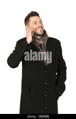 Junger Mann, der vor weißem Hintergrund telefoniert. Bereit für den Winterurlaub Stockfoto