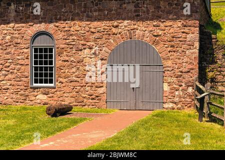 Morgantown, PA / USA - 29. April 2020: Eine runde Außentür auf einem historischen Steingebäude im ländlichen Pennsylvania. Stockfoto