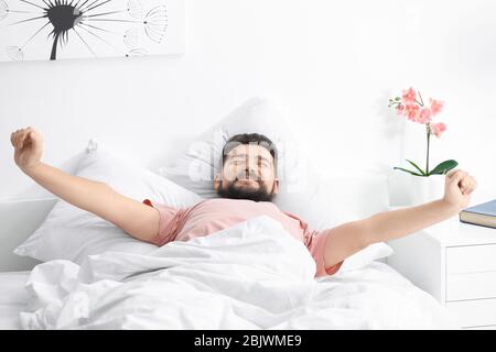 Morgen des Mannes Stretching im Bett zu Hause Stockfoto