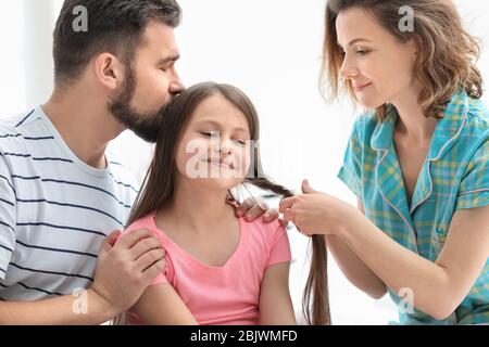 Morgen der glücklichen Eltern mit kleinen Tochter im Schlafzimmer Stockfoto