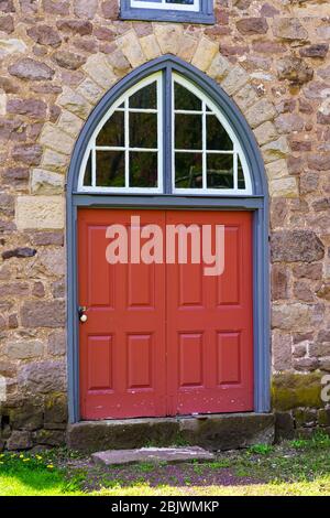 Morgantown, PA / USA - 29. April 2020: Eine runde Außentür auf einem historischen Steingebäude im ländlichen Pennsylvania. Stockfoto