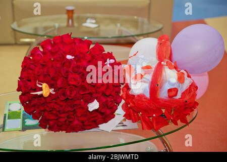 Großer Strauß von hundert großen roten Rosen Blumen. Der Griff des Verlobungskorbes rot. Ein Blumenstrauß von hundert roten Rosen. Stockfoto