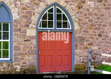 Morgantown, PA / USA - 29. April 2020: Eine runde Außentür auf einem historischen Steingebäude im ländlichen Pennsylvania. Stockfoto