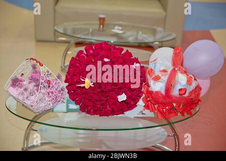 Großer Strauß von hundert großen roten Rosen Blumen. Der Griff des Verlobungskorbes rot. Ein Blumenstrauß von hundert roten Rosen. Stockfoto