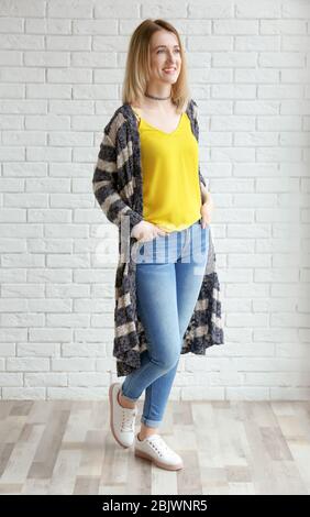 Junge Frau in gestreifter Strickjacke im Innenbereich Stockfoto
