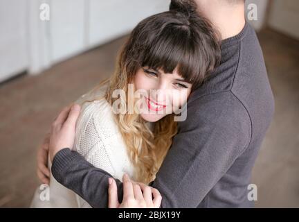Junge liebevolle Paar Umarmung drinnen Stockfoto