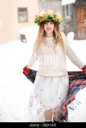 Porträt der jungen Frau trägt schöne Blumenkranz im Freien am Wintertag Stockfoto