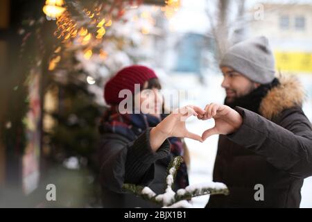 Junge liebevolle Paar Herz mit Händen im Freien am Wintertag Stockfoto