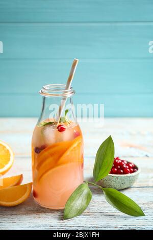 Flasche leckere Orangenlimonade mit Cranberry auf Holztisch Stockfoto